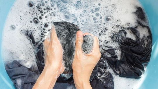 Washing cotton clothes by hand in a large basin