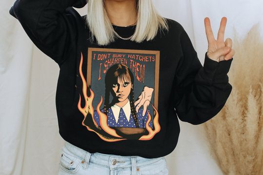 Nevermore Academy sweatshirt, Wednesday Addams TV show, sharpen hatchets, Mortician Addams daughter