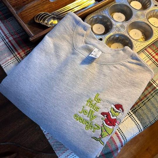 Discover Embroidered funny character Christmas Sweatshirt, Funny Holiday Hoodie "Is This Jolly Enough?", Cute Xmas Graphic Gift Shirt, Feeling Grin