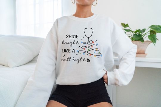Discover Funny Nurse Christmas Sweatshirt: Shine Bright Call Light Design
