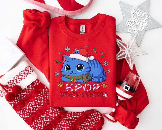 Discover KPOP DEMON HUNTERS Christmas Sweatshirt, Cute Blue Cat with Santa Hat Design, Whimsical Kawaii Holiday Apparel for Fans
