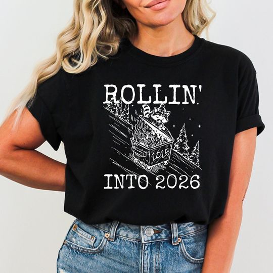 Discover Comfort Colors Rollin Into 2026 Shirt, Sarcastic Raccoon New Year Tee, Funny Holiday T-Shirt
