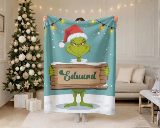 Discover Personalized funny character Holding Name Board Christmas Santa Hat Cozy Fleece Blanket