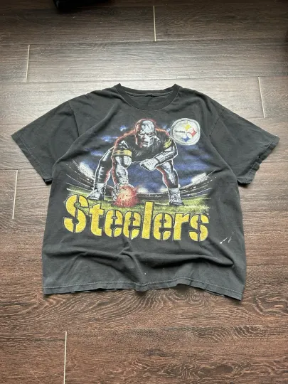 Discover Vintage Steeler football lineman graphic tee with Steeler robot on front