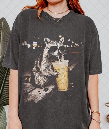 Discover Comfort Colors Raccoon Drinking Iced Coffee Shirt, Funny Animal Meme Tee, Coffee Lover Raccoon Shirt, Gift For Women and Man Unisex T-Shirt
