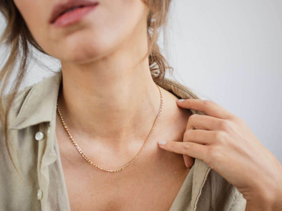 Woman wearing a thin chain inside a collared shirt